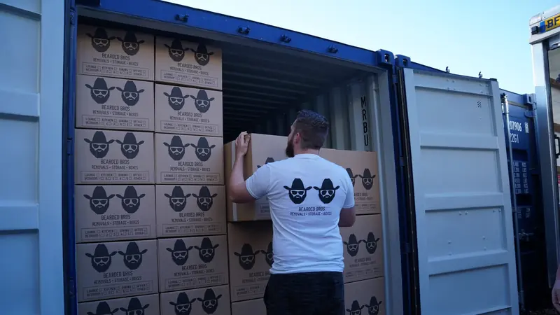 Bearded Bros crew member loading branded boxes into a storage container