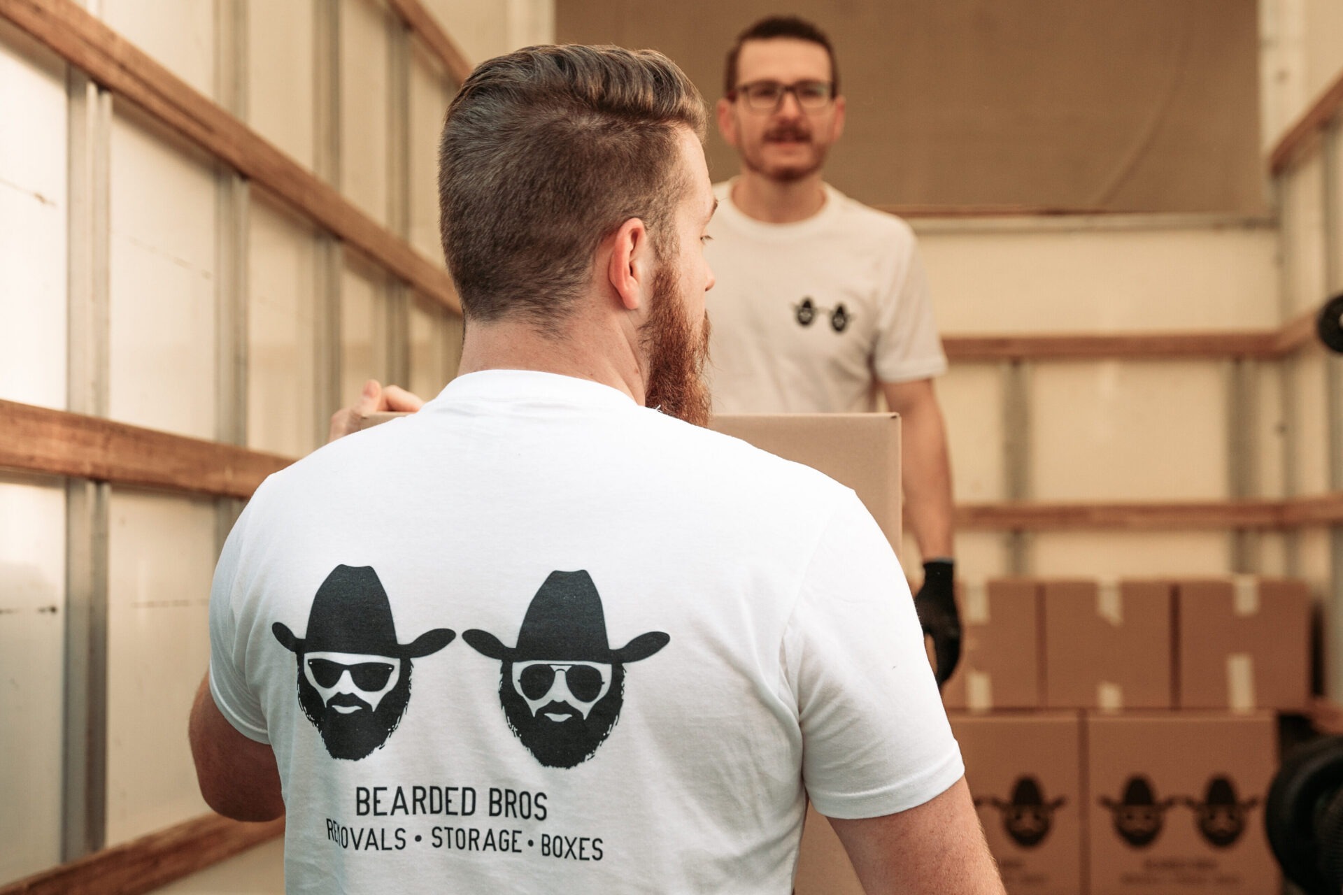Bearded Bros crew member carrying labelled boxes through a hallway in a Shoreham property
