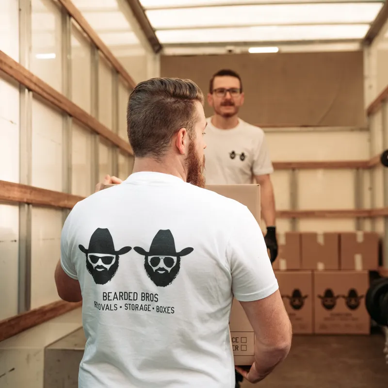 Bearded Bros removals crew loading boxes into a storage container in Brighton