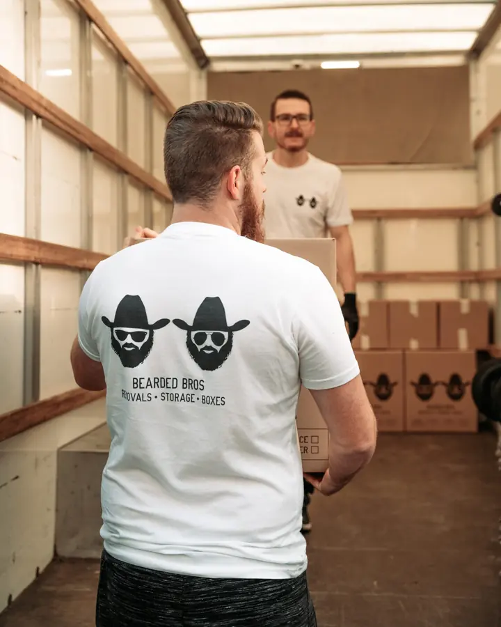 Bearded Bros removals crew loading boxes into a storage container in Brighton