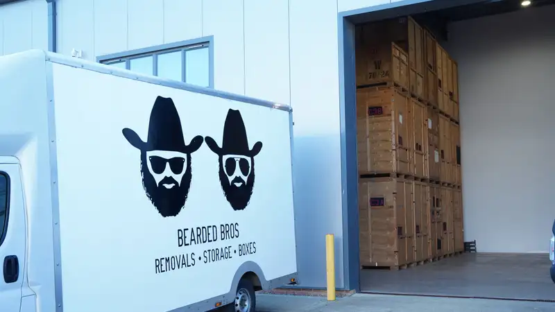 Bearded Bros branded removals van parked at the Brighton depot with storage crates visible