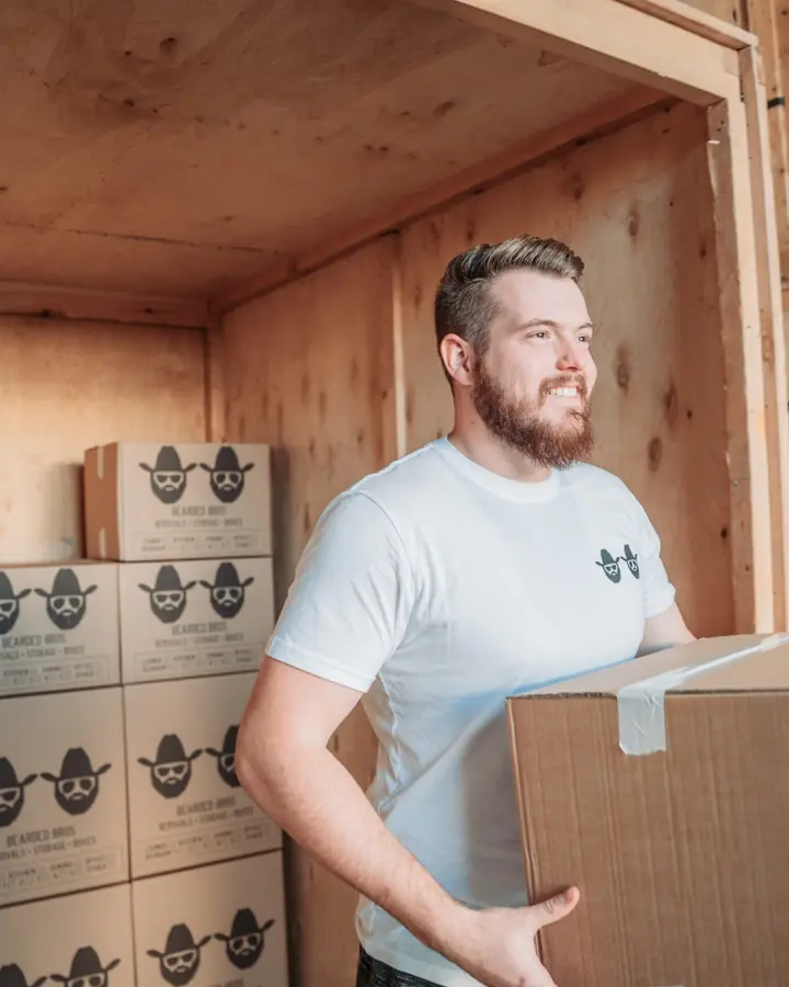 Bearded Bros team member carrying a branded moving box