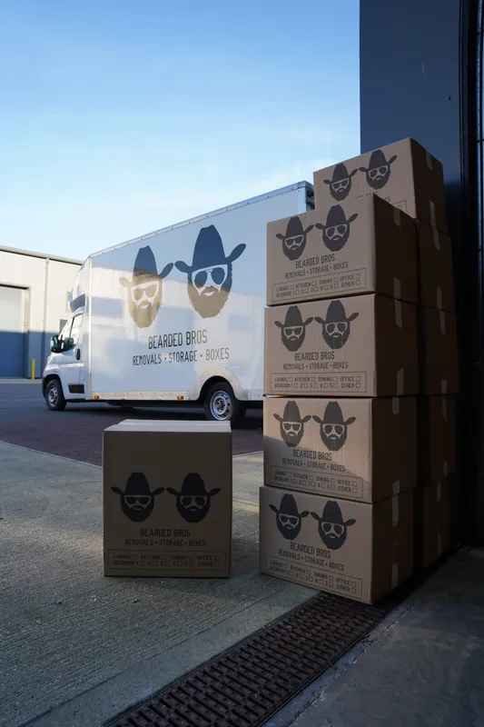 Bearded Bros removal van and branded moving boxes outside the depot
