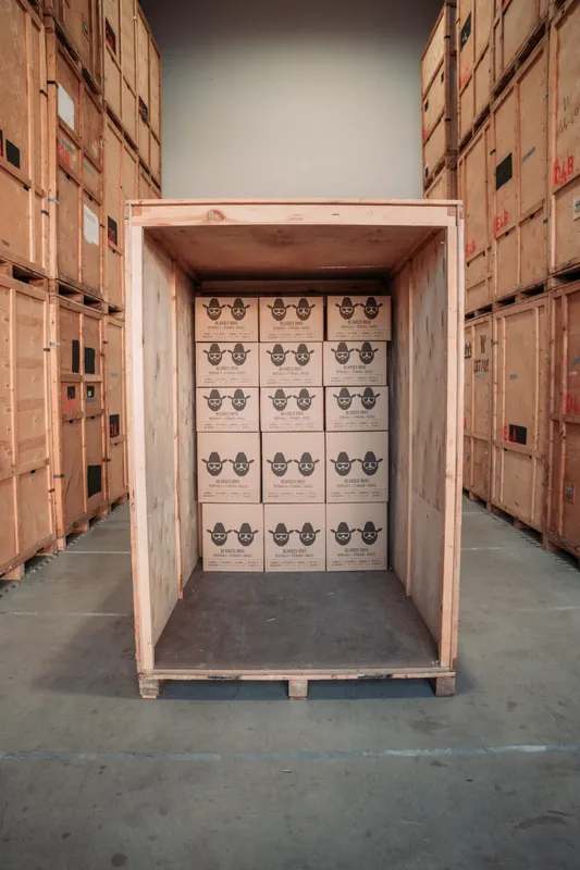 Open wooden storage crate packed with Bearded Bros branded boxes at Newhaven